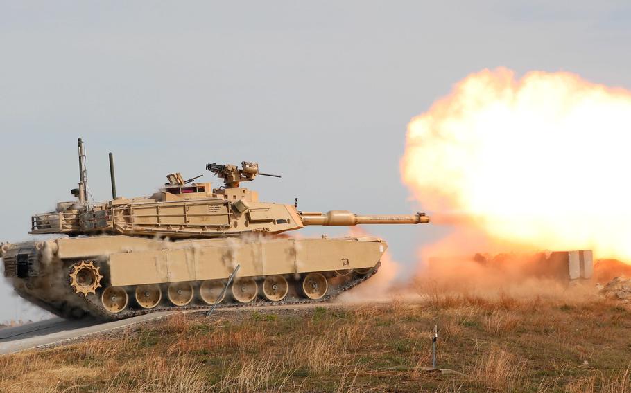 An M1A1 Abrams tank operated by soldiers with the 2nd Battalion, 70th Armored Regiment, 2nd Armored Brigade Combat Team, 1st Infantry Division fires over a barricade at the Douthit Gunnery Complex on Fort Riley, Kan., on Oct. 20, 2022. 