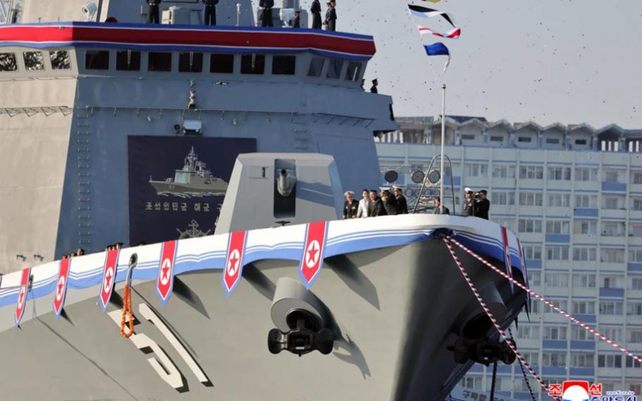 Pyongyang’s new destroyer, adorn with North Korean flags, is docked at a port.