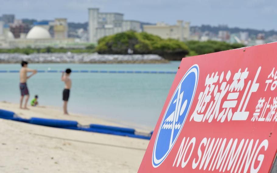A sign in Japanese and English warns people not to swim at Araha Beach in Chatan, Okinawa, Thursday, May 19, 2022. 
