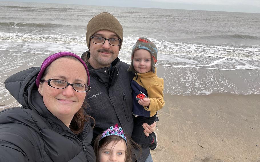 The Anders family poses for a photo on a beach. 