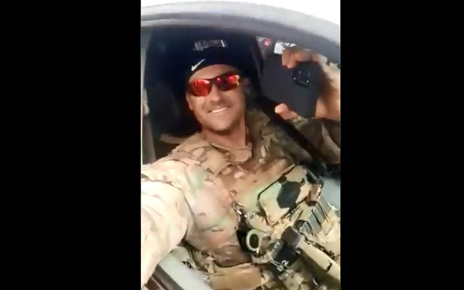 In a screenshot from a Twitter video, a Green Beret smiles at the crowd as Guinean troops escort the U.S. Africa Command team to the U.S. Embassy in the country. 