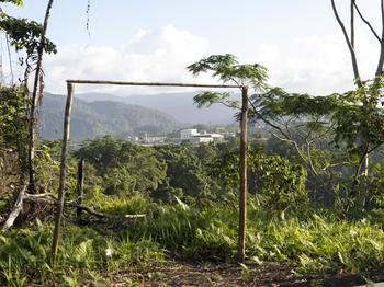 Through a makeshift children's soccer goal about two hours outside Honiara, Gold Ridge mine is visible. 