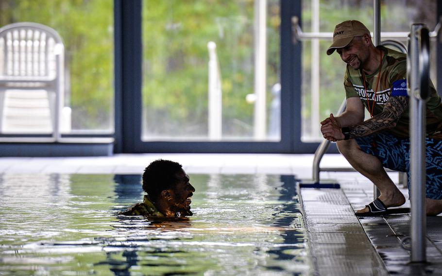 German air force Senior Master Sgt. Benjamin Angel, a training NCO with NATO Allied Air Command, checks in with U.S. Air Force Senior Airman Sequan Holness, a mechanic with the 86th Vehicle Readiness Squadron, after Holness did not complete the swim portion of the German Armed Forces Badge for Military Proficiency in time at Ramstein Air Base, Germany, April 22, 2024. Holness had taught himself to swim just a week before the test.