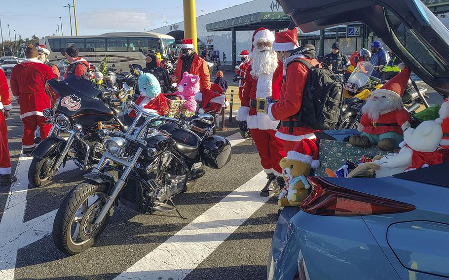 Bikers dressed as Santa gather at a highway rest stop in Ebina, Japan, to deliver hundreds of toys that will be donated to Japanese children's homes, Sunday, Dec. 5, 2021.