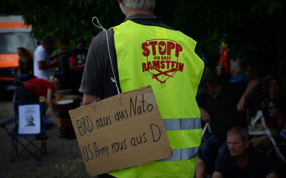 A protest participant carries a sign during a peace protest in Ramstein-Miesenbach, Germany, June 25, 2022. His hand-written sign calls for Germany to leave NATO and U.S. troops to leave the country. 