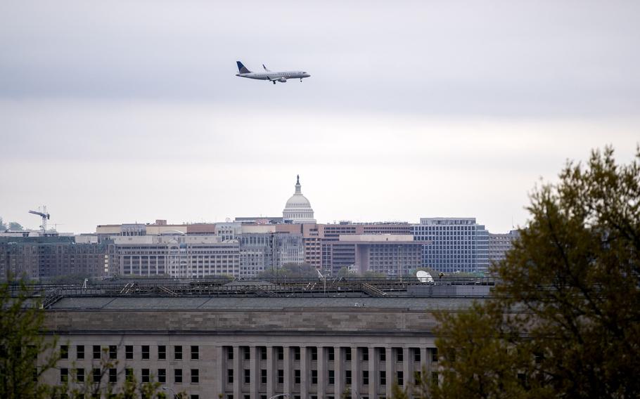 A United Airlines plane flies above the U.S. Capitol and the Pentagon building in Arlington, Va.., on April 9, 2021. MUST CREDIT: Bloomberg photo by Stefani Reynolds.