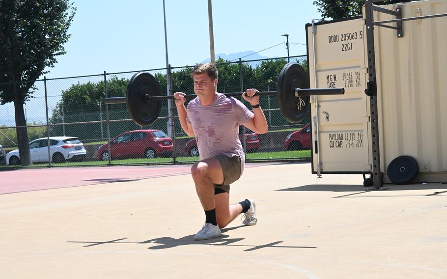 A man lifts weights outside.