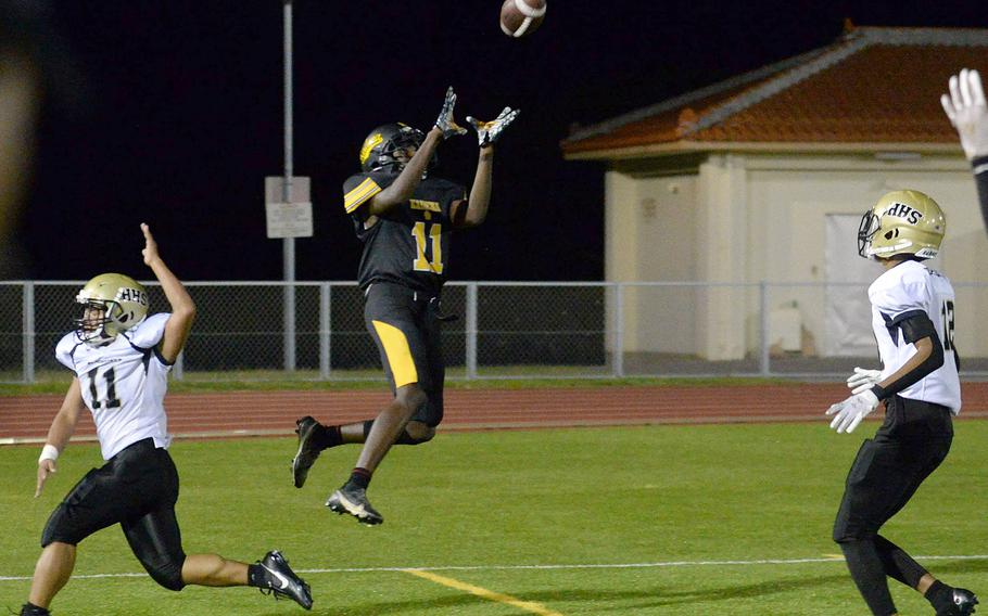 Kadena's Sadiiq Haynes goes up for a 13-yard touchdown catch between Humphreys defenders Marvin Gibson and Brian Taylor.