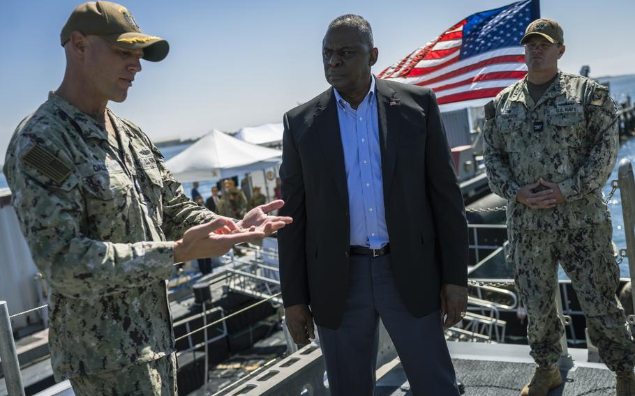 Defense Secretary Lloyd J. Austin III, center, tours a vessel at Naval Station Point Loma in San Diego, Calif., Sept. 28, 2022. Austin promised to help service members pay for sharp increases in living costs, such as housing, food and child care, in high-cost areas such as Southern California.