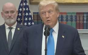 President Donald Trump speaks with Rep. Derrick Van Orden and Rep. Mike Bost standing next to him.