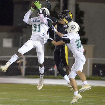 Kubasaki's Malachi Pinkston goes up for an interception against Kadena's Javonte Vickers as Dragons teammate Andrew Welte looks to help.