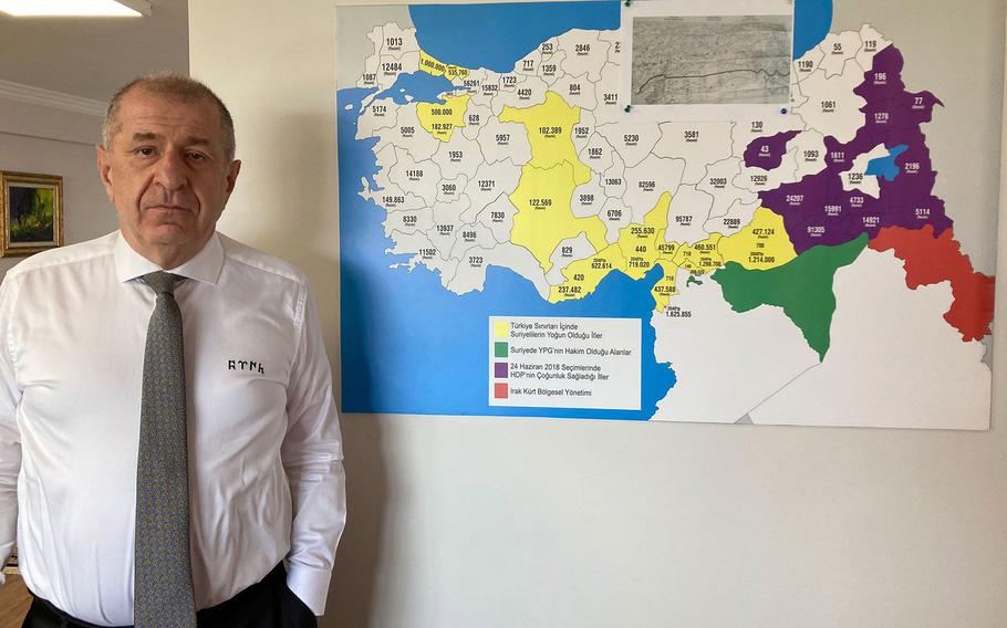 Umit Ozdag at his Ankara office, alongside a map showing refugee density across Turkey. 