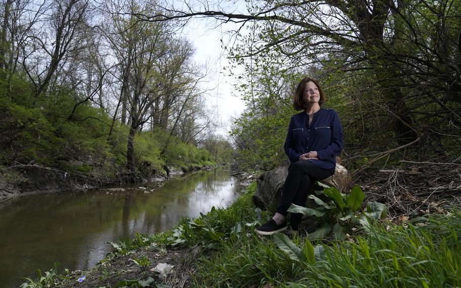 Susie Gaffney poses for a photo along Coldwater Creek near where she used to live Friday, April 7, 2023, in Florissant, Mo. The creek was contaminated when nuclear waste from the Manhattan Project flowed into the waterway past homes, schools and businesses. St. Louis played an important role in the country’s effort to build the first nuclear weapon. 