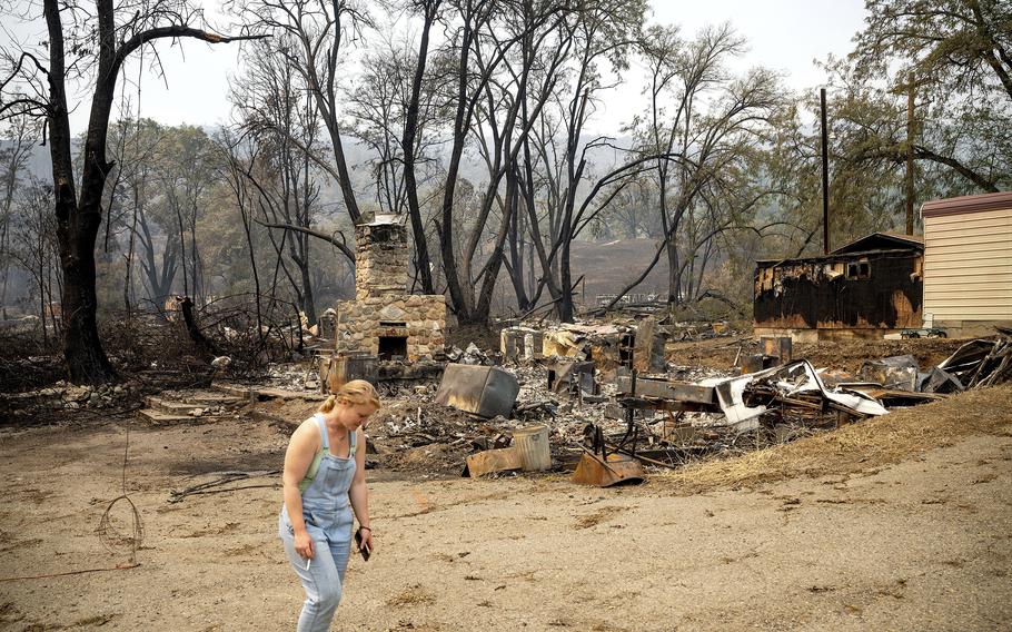 Sydney Corrales passes a lodge that burned during the McKinney Fire, Tuesday, Aug. 2, 2022, in Klamath National Forest, Calif.