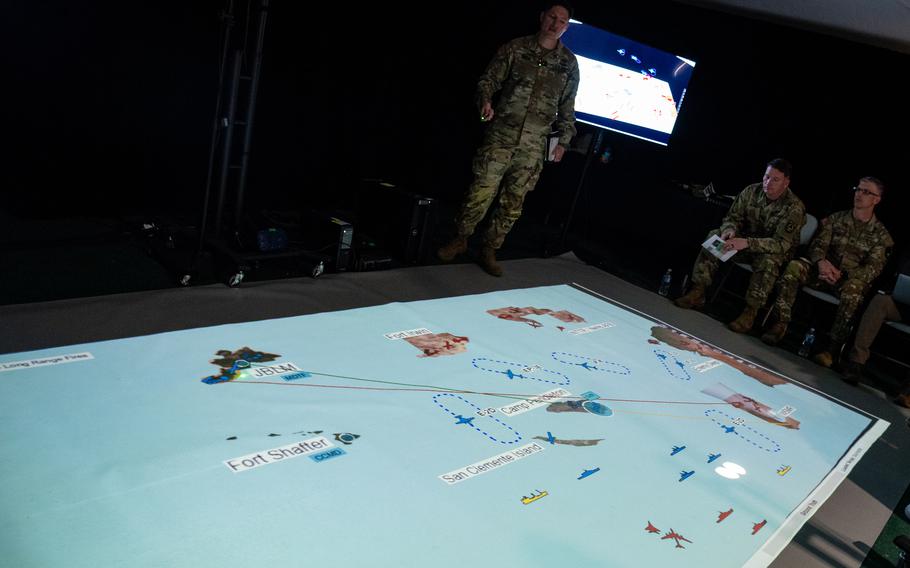 Army Maj. John Donaho, a capability integrator team leader for Joint Modernization Command, top left, explains the scenarios and battlespace involved in the Army’s 2024 Project Convergence capstone event on March 5, 2024, at Camp Pendleton, Calif. 
