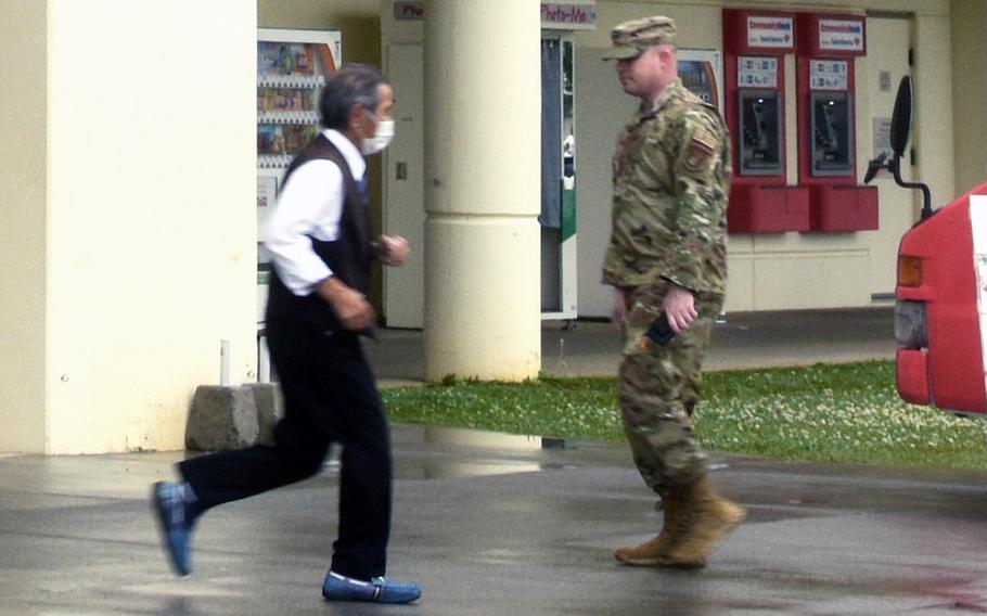 People walk outside an exchange store at Kadena Air Base, Okinawa, Wednesday, March 23, 2022.