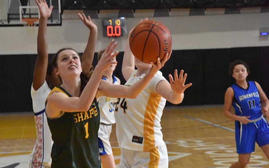 SHAPE guard Jessie Moon used a scoop shot to try to avoid taller defenders Saturday, Feb. 24, 2024, during the DODEA-Europe Girls All-Star Basketball Game in Vicenza, Italy.