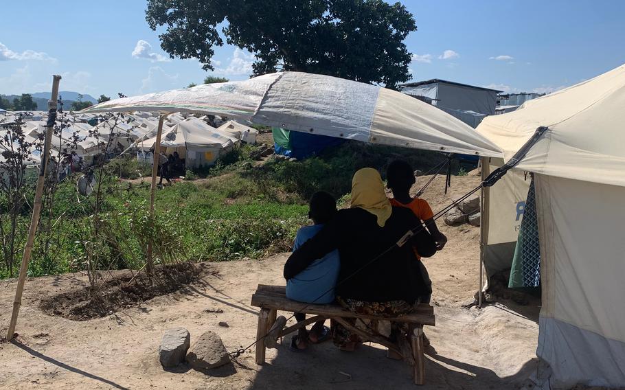A Sudanese doctor sits under a tarpaulin with her children at a camp in northern Ethiopia’s Amhara region. 