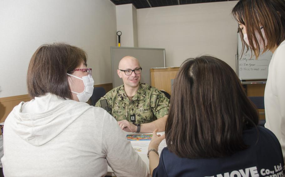 Navy chaplain (Lt.) Jacob Meyer from the aircraft carrier USS Ronald Reagan speaks with Japanese visitors at the cultural exchange center at Yokosuka Naval Base, Japan, on March 29, 2023. 