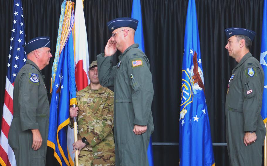 Incoming commander Col. Richard F. McElhaney, center, receives the 374th Airlift Wing guidon from Lt. Gen. Ricky N. Rupp, commander, U.S. Forces Japan, as outgoing commander Col. Andrew Roddan looks on at Yokota Air Base, Japan, July 9, 2024.