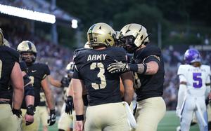 Football players in the black and gold West Point athletics uniform.