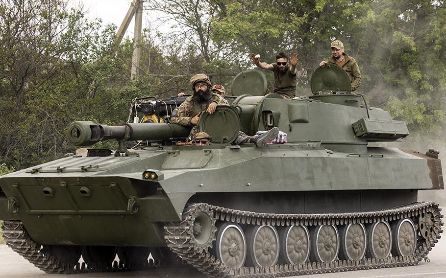 A Ukrainian soldier on an armored vehicle holds up an ice cream cone, in the Zaporizhzhia region on Saturday, May 21, 2023.