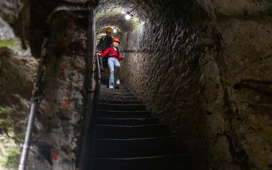A family descends the stairs Sept. 21, 2024, to the lava caverns in Mendig, Germany. The caverns, located 105 feet underground, were formerly used for basalt mining and provided cool storage for local breweries.