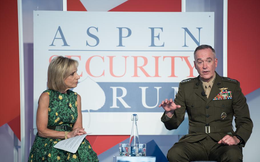 A woman and a man in uniform sitting. She listens as he speaks.