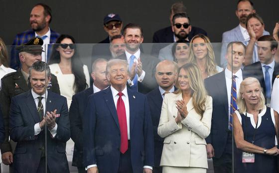 President Donald Trump, first lady Melania Trump, and Defense Secretary Pete Hegseth, left, attend a military parade.