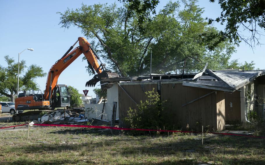 An excavator demolishes a house at Tyndall Air Force Base, Fla., April 1, 2021, that was severely damaged by Hurricane Michael in October 2018.