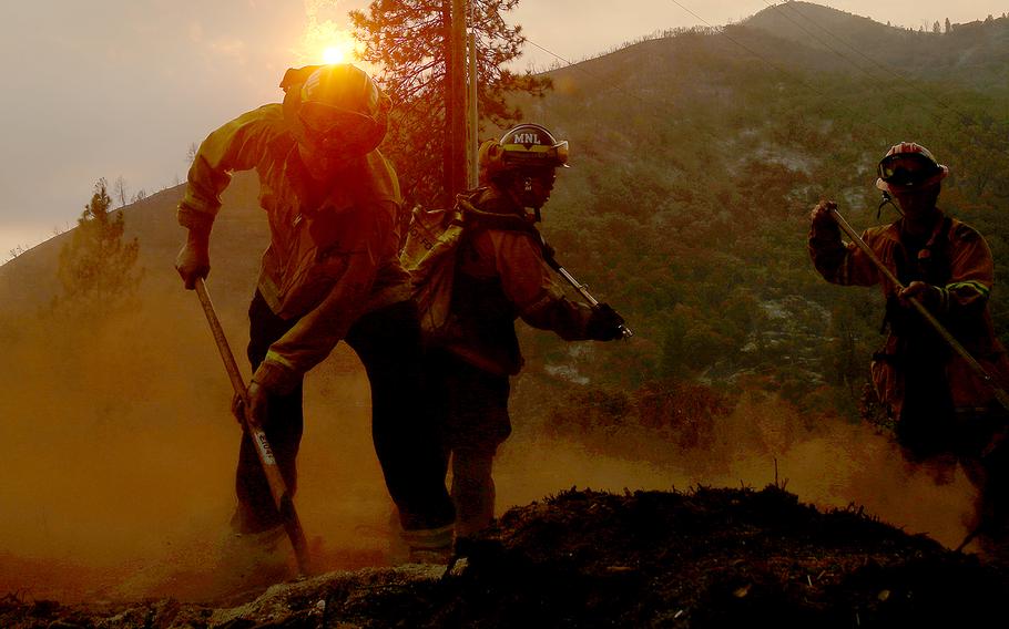 Firefighters put out hotspots from the Oak fire along Darrah Road near Mariposa on Tuesday, July 26, 2022. 