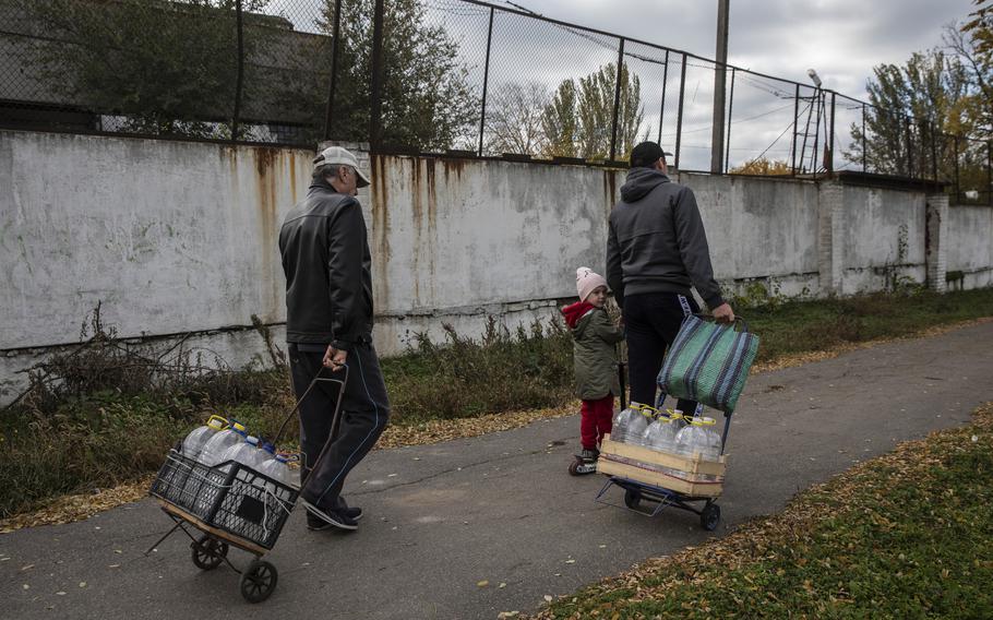 Residents use carts to take home plastic bottles of clean water in Mykolaiv. 