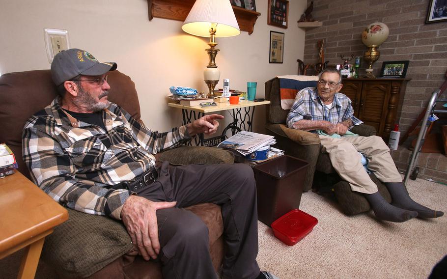 Robert "Doug" Adams, left, speaks with his father John Adams at John's home in Plain Township, Ohio, on Jan. 26, 2022. Doug Adams said his dad never talked about his combat experiences in the South Pacific.