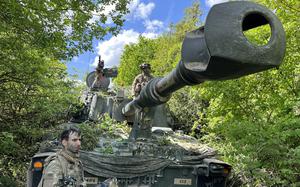 Army Staff Sgt. Matthew Daliege, an M109A7 Paladin section chief, left, and driver Pfc. Benjamin Cosby camouflage their mobile artillery system during exercise Combined Resolve at the Joint Multinational Readiness Center in Hohenfels, Germany, on May 20, 2025.