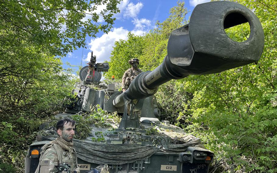 Soldiers camouflage their mobile artillery system during exercise Combined Resolve