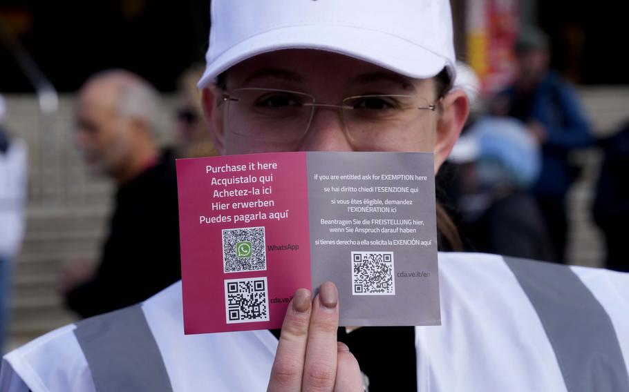 A steward shows the QR code access outside the main train station in Venice, Italy, Thursday, April 25, 2024. 