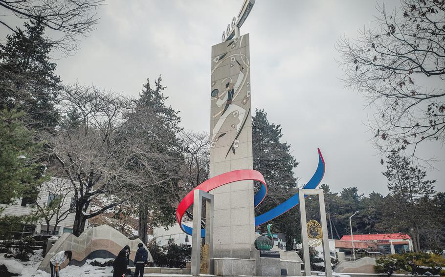 A vertical stone monument with colorful flourishes near its base sits at Eunpa Lake Park in Gunsan, South Korea. 