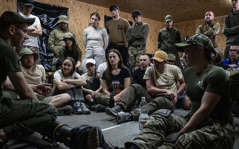 Ukrainian civilians are shown how to operate an anti-tank weapon on a military training course run by the Azov Battalion. 
