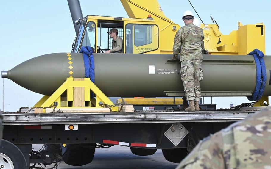 U.S. airmen look at a GBU-57, or the Massive Ordnance Penetrator bomb on a truck trailer.