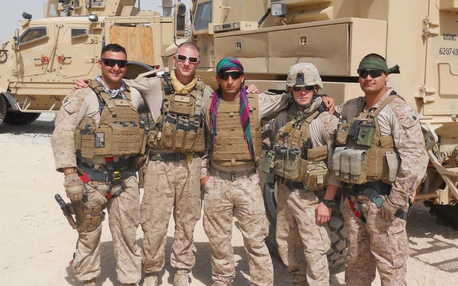 Mohammad Nadir, center, poses with Marines in Helmand province, Afghanistan, in 2017. Nadir served as an interpreter for nearly three years before applying for a U.S. Special Immigrant Visa. Nadir later enlisted in the Marine Corps.