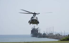 A helicopter prepares to land at White Beach Naval Facility.