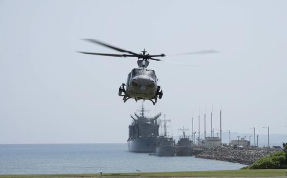 A helicopter prepares to land at White Beach Naval Facility.