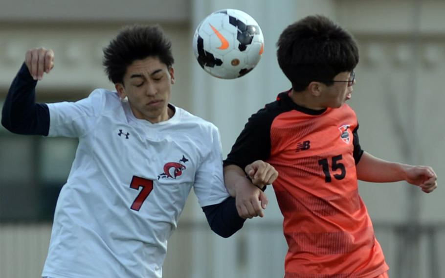 E.J. King's Kaito Bergman and Nile C. Kinnick's Ethan Tomlin go up to head the ball during Saturday's DODEA-Japan soccer match. The Red Devils won 8-1.
