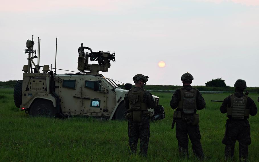 Members of the 3rd Marine Littoral Regiment watch the sun set near the South China Sea during a Balikatan drill.