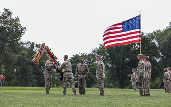 Maj. Gen. John V. Meyer III passes the 1st Infantry Division colors to Lt. Gen. Sean C. Bernabe, III Armored Corps Commander, on Cavalry Parade Field, Fort Riley, Kansas June 28, 2024. 
