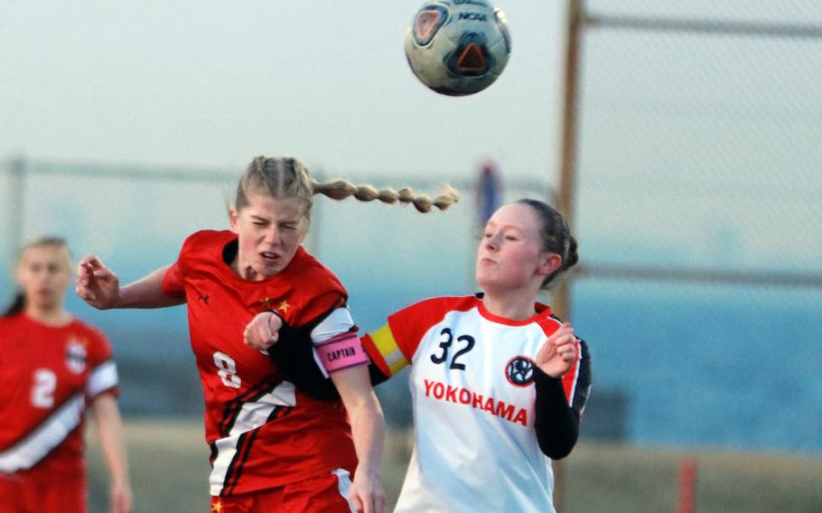 Nile C. Kinnick's Bree Withers heads the ball against Yokohama International's Anna Kvalheim  during Monday's Japan girls soccer match. The Red Devils won 4-0.