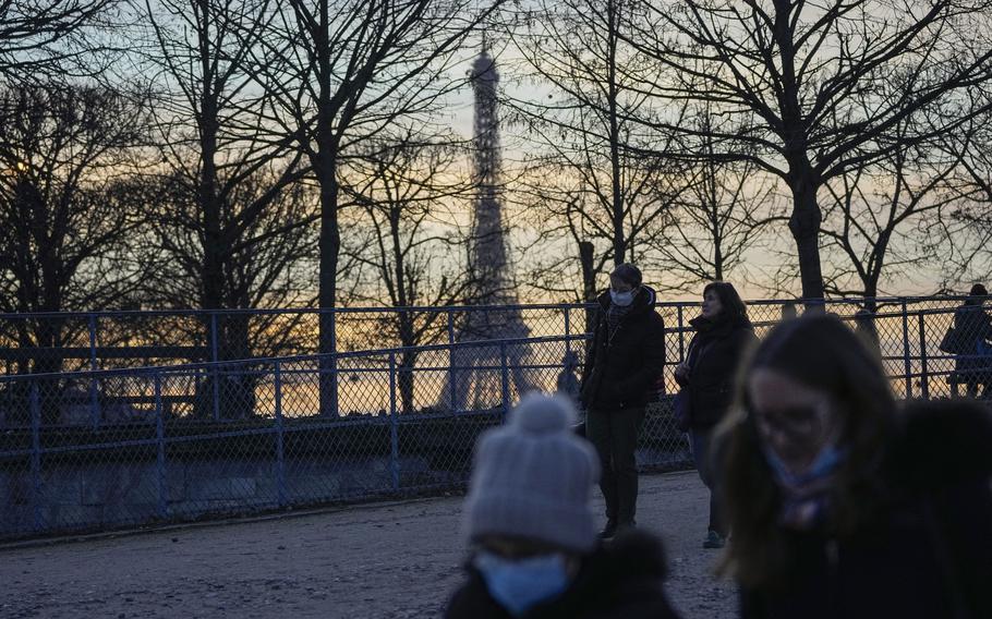 People wearing face masks to protect against COVID-19 walk at Tuilerie garden in Paris, Thursday, Dec. 9, 2021. 