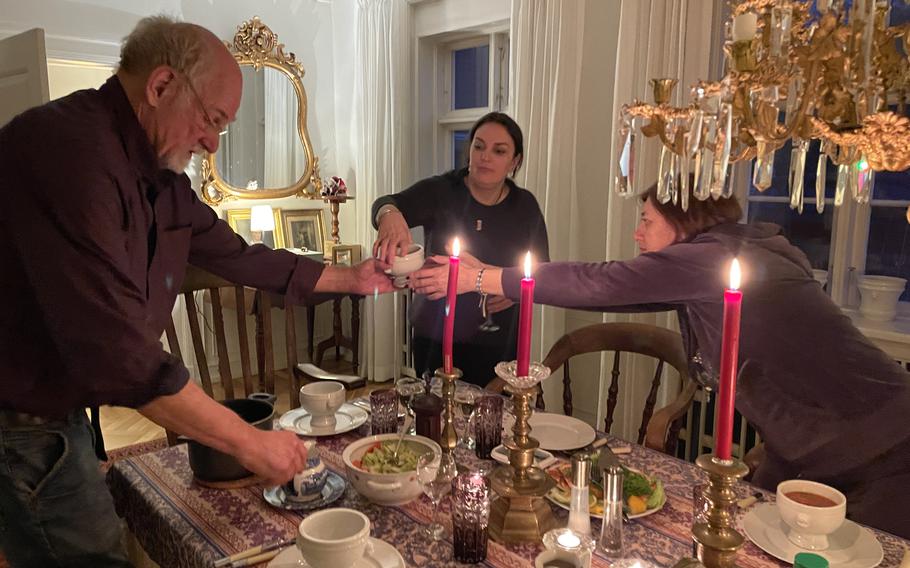 Two Ukrainian women, along with Steffen Møller, at dinner in a farmhouse in Denmark.
