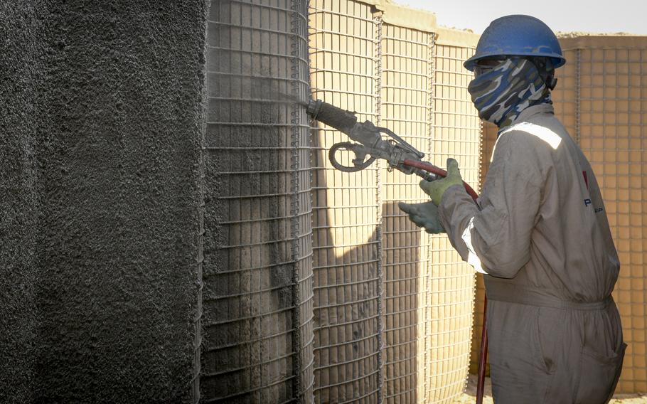 A worker sprays a thick epoxy coating on the walls of a Hesco barrier at Ali Al Salem Air Base in Kuwait on Nov. 28, 2022. The coating is part of a new bunker design and will help prevent the barriers, which are filled with sand, from deteriorating due to the elements, base engineers said. 