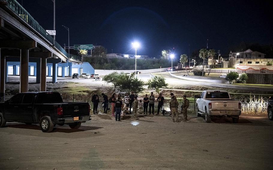 Migrants are apprehended by US Border Patrol and National Guard troops in Eagle Pass, Texas, near the border with Mexico on June 30, 2022.